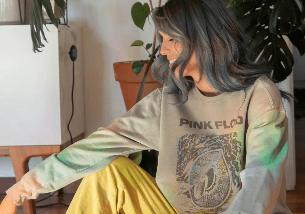 Women in pink floyd sweatshirt in front of plants