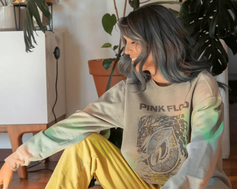 Women in pink floyd sweatshirt in front of plants