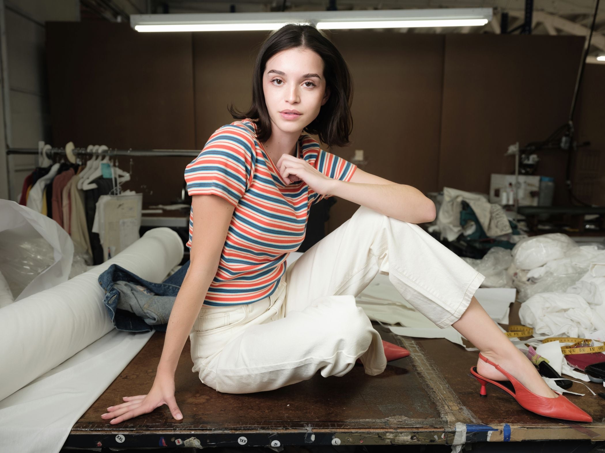 Women sitting beside outdoor pool wearing a blue kimono while looking down at a book.